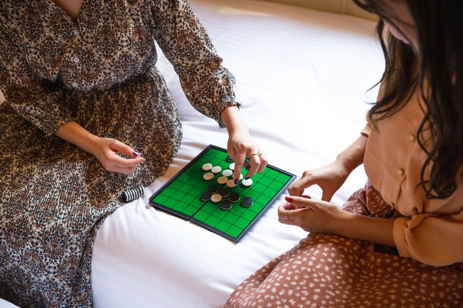 室内でボードゲームを楽しんでいる二人の女性たちが、心地よい余暇を過ごしています。